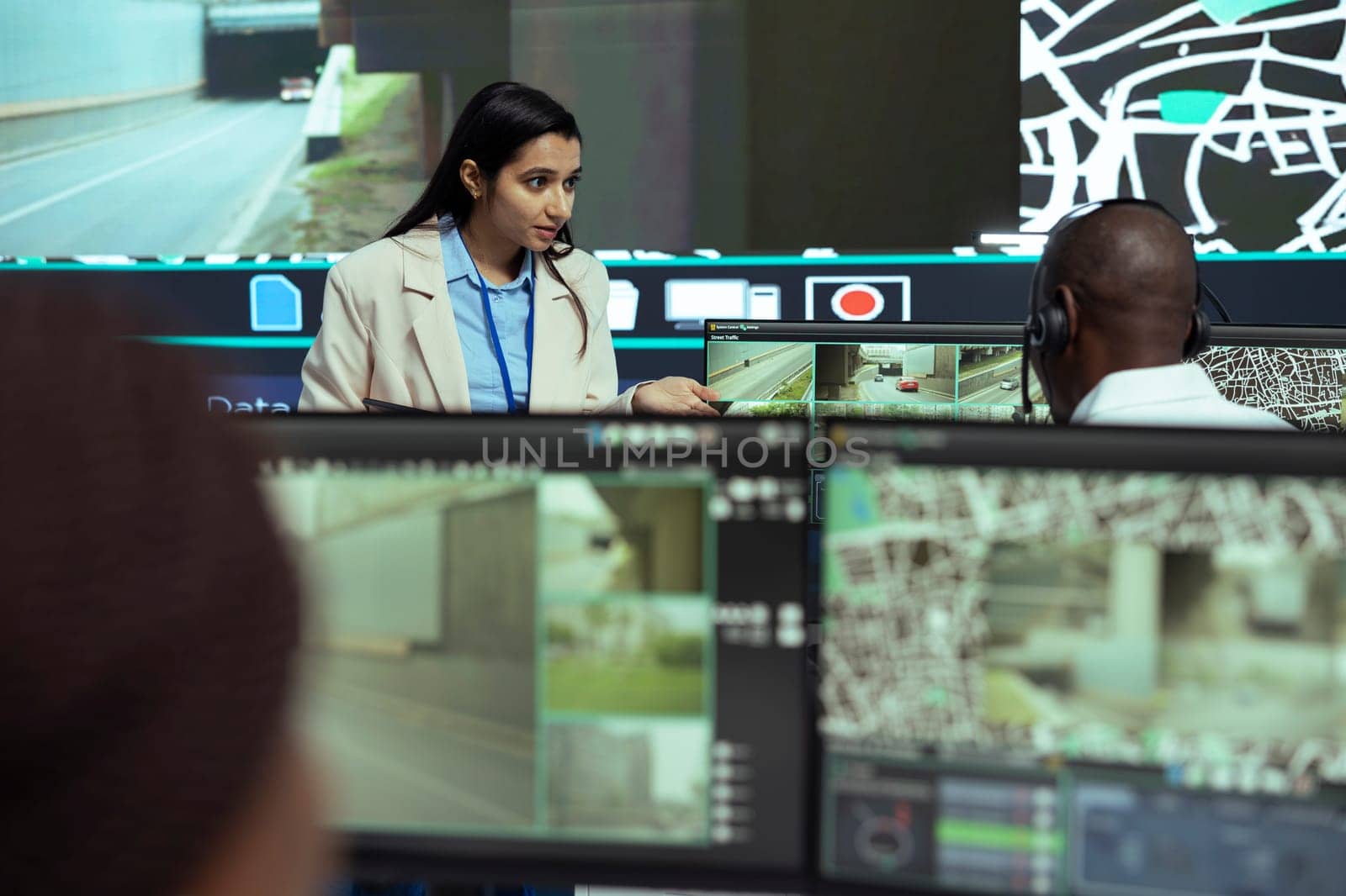 Indian supervisor gives instructions to her team in monitoring room by DCStudio