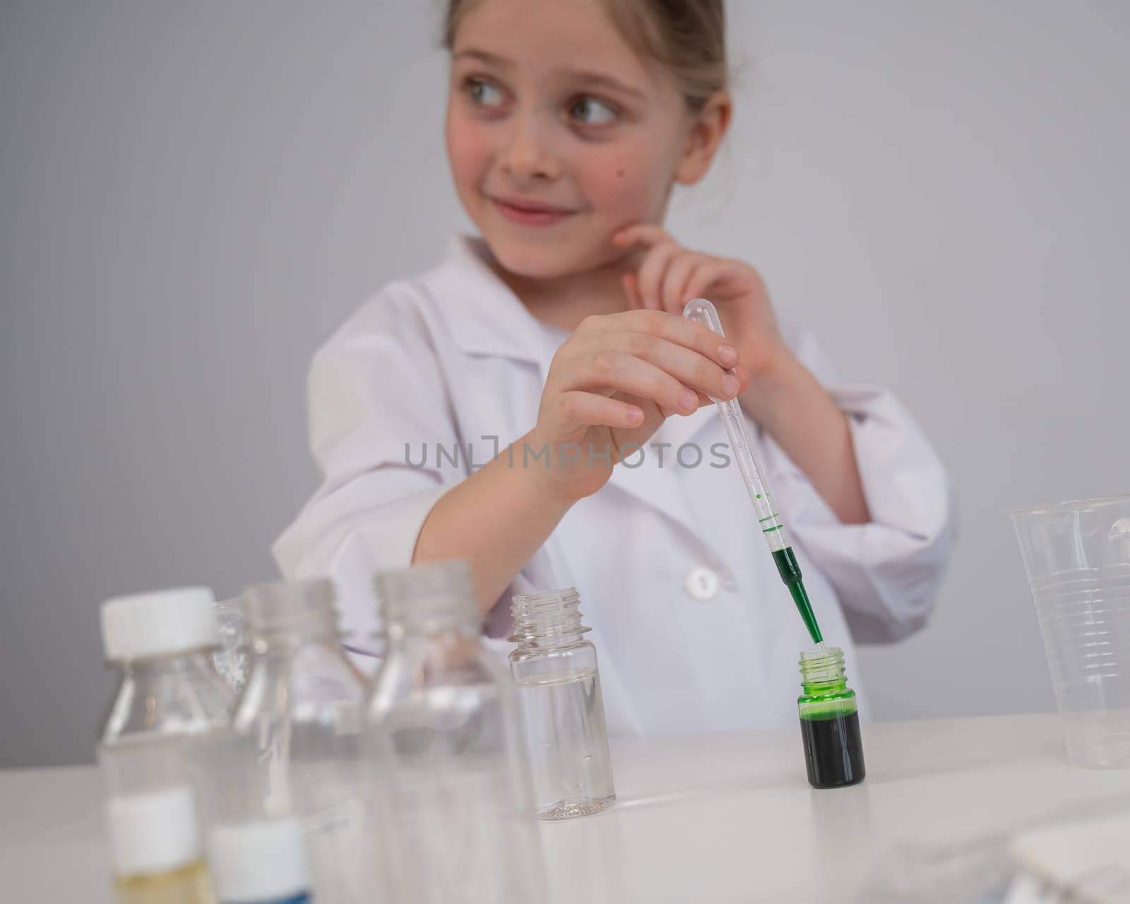 Caucasian girl doing chemical experiments on a white background