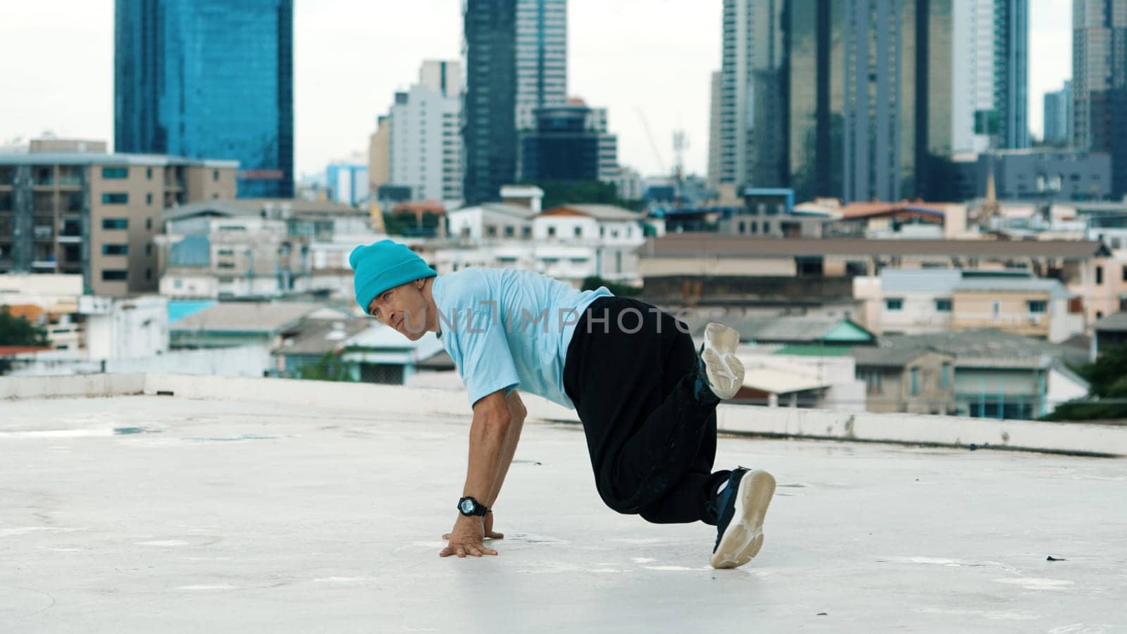 Skilled caucasian B-boy dancer practicing street dancing at rooftop. Endeavor. by biancoblue