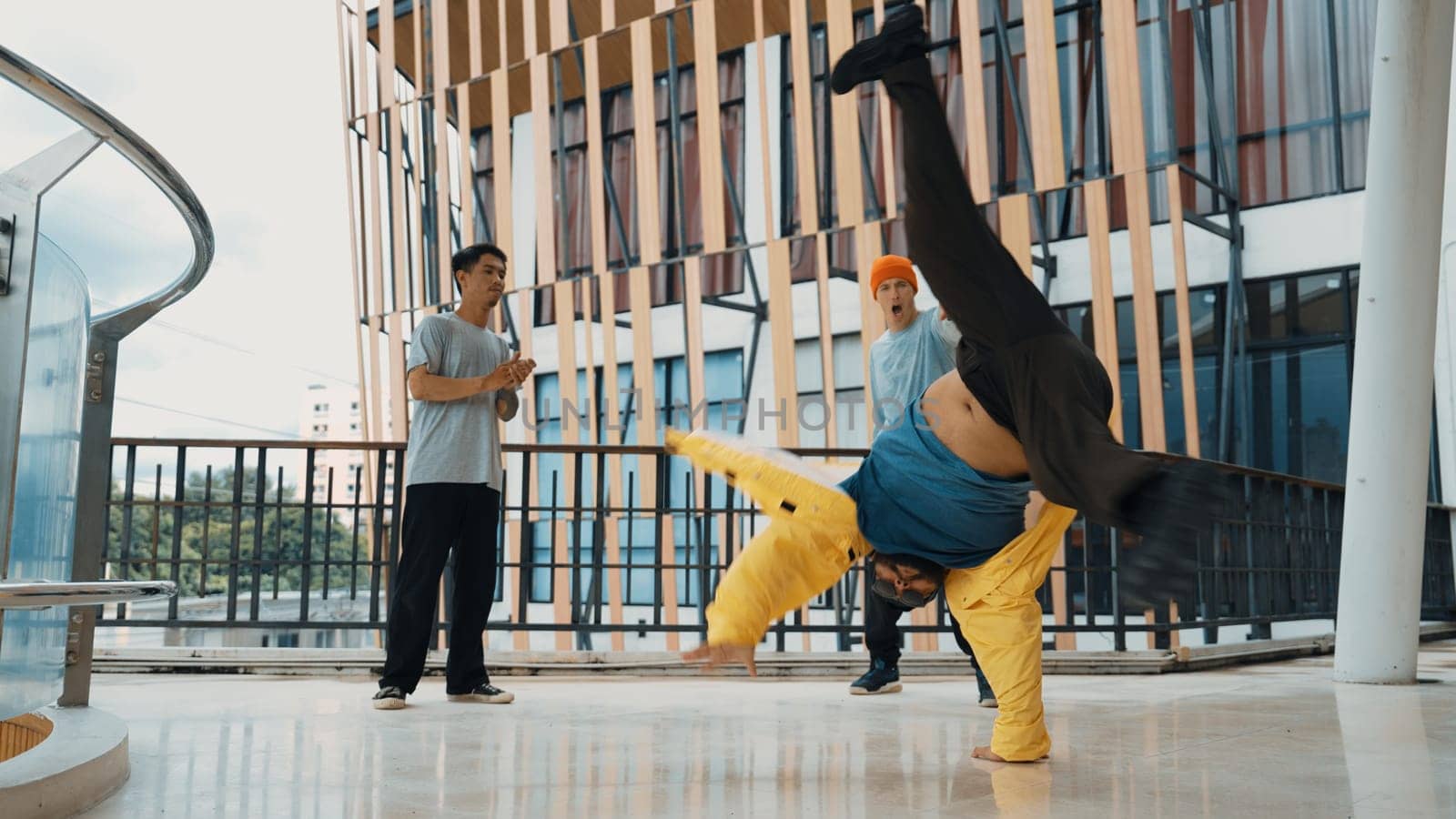 Hip hop team dance break dance while multicultural friend surrounded and clapping hands to cheer or encourage his friend to dance. Active and energetic street dance. Outdoor sport 2024. Endeavor.