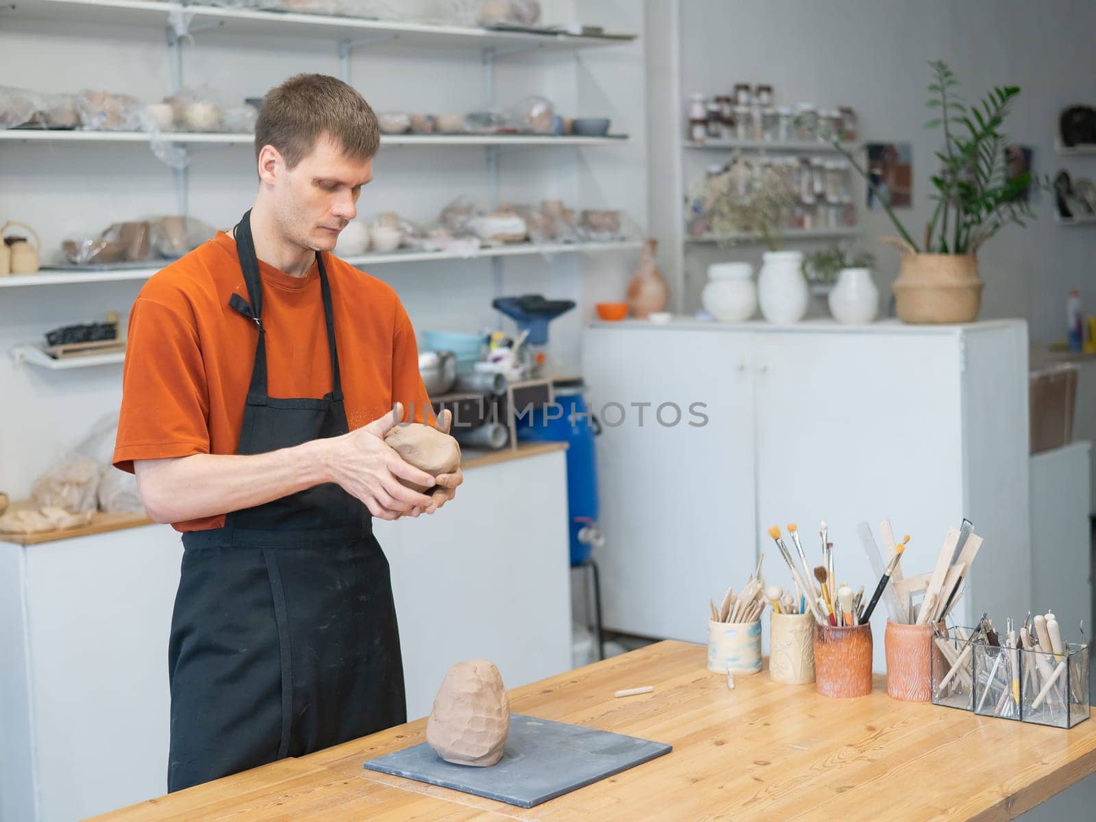 A potter kneads clay before using it in the workshop. Close-up of a man's hands