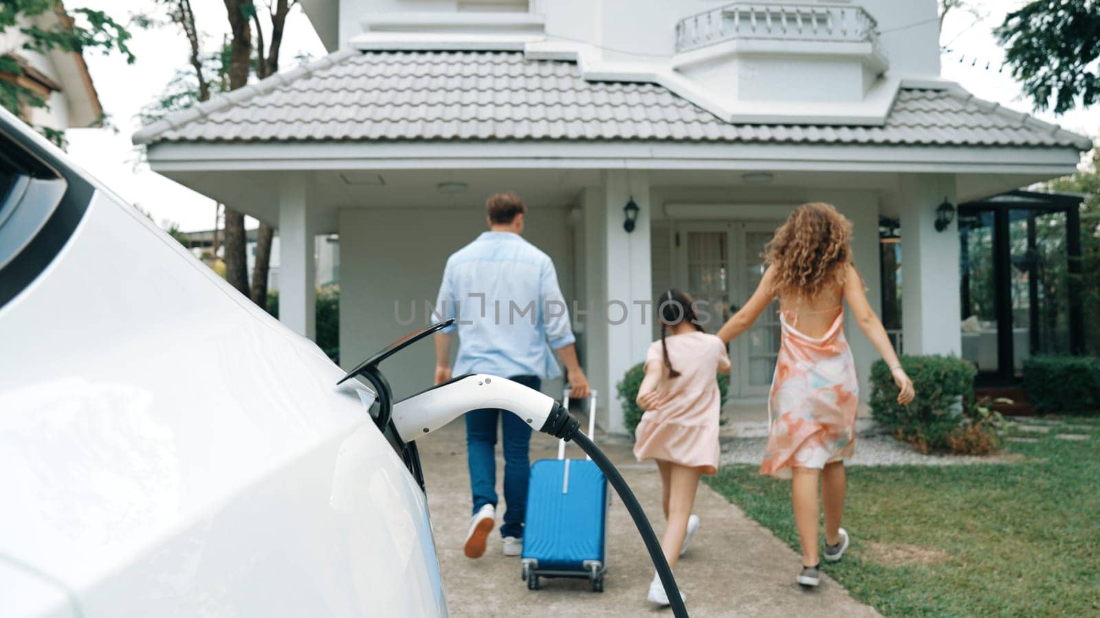 Happy family return from holiday and travel using EV car. Synchronos by biancoblue