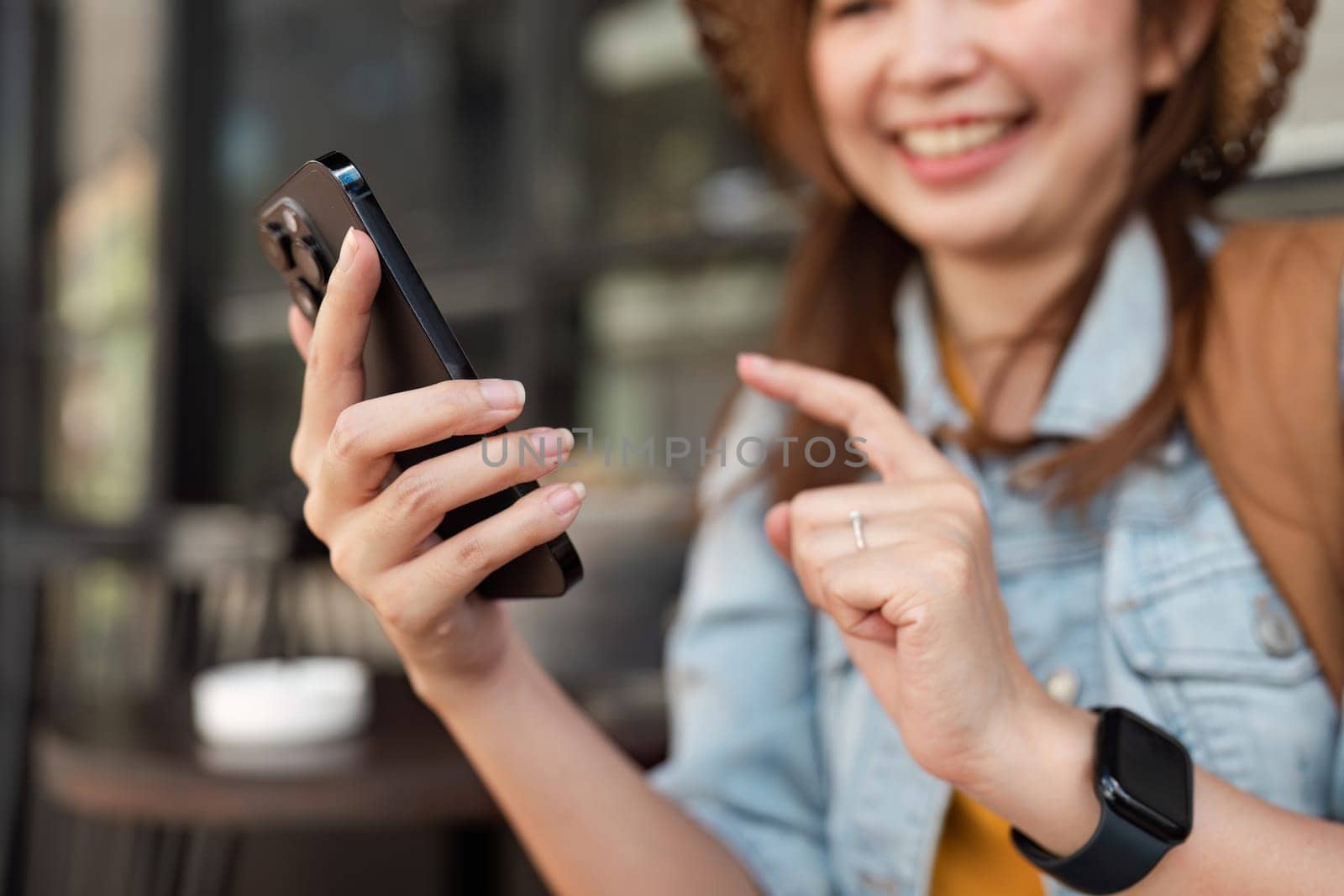 A cheerful traveler in casual attire uses a smartphone for navigation and communication during her city exploration.