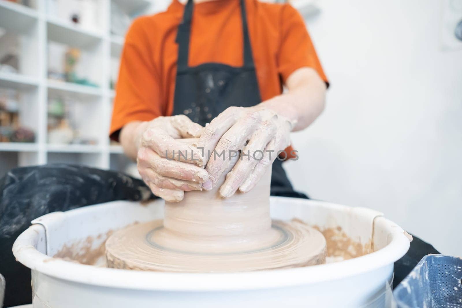 Close-up of a potter's hands working on a pottery wheel. by mrwed54