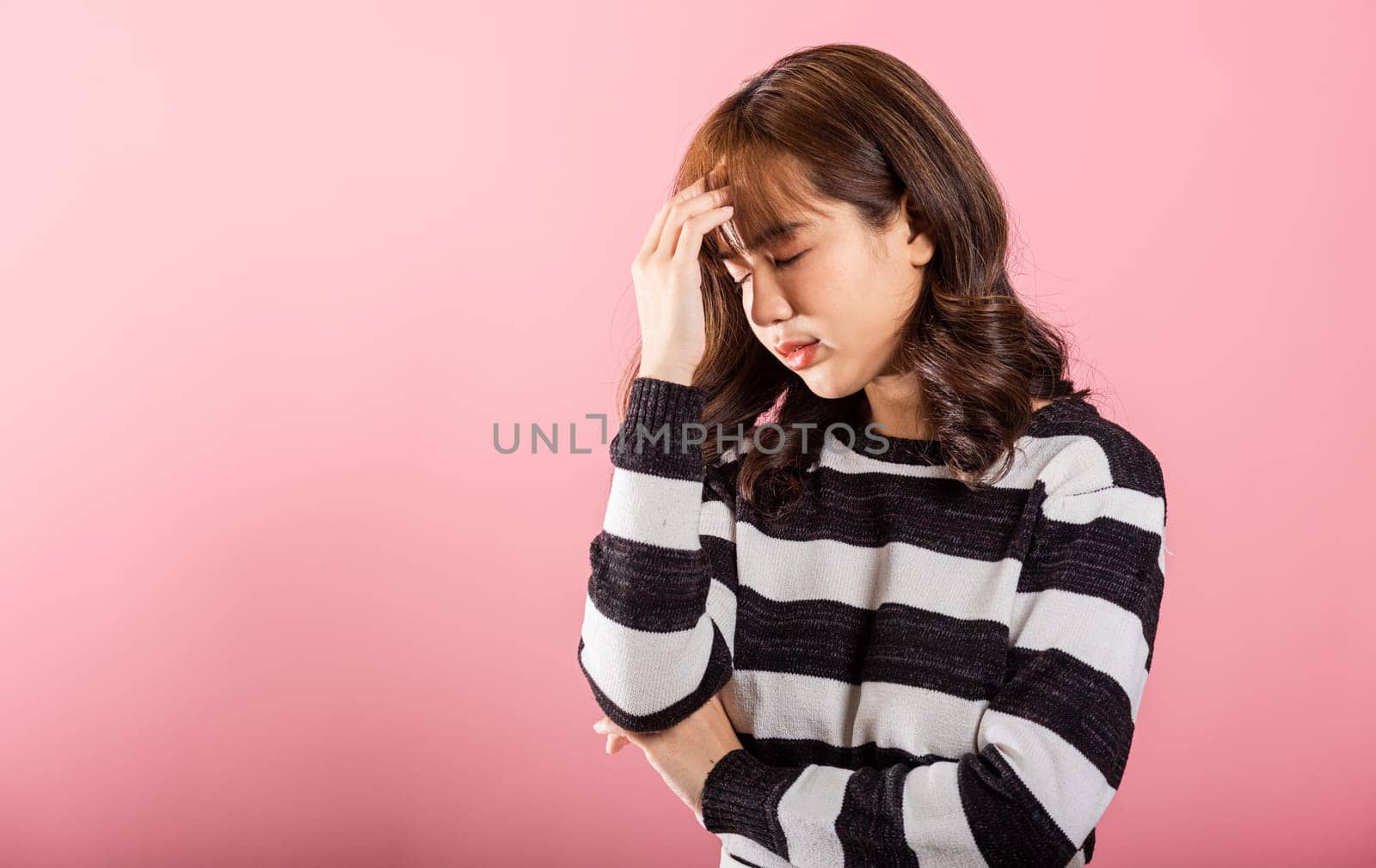 Portrait of beautiful Asian young woman sad tired strain face holding hold head by hands by Sorapop