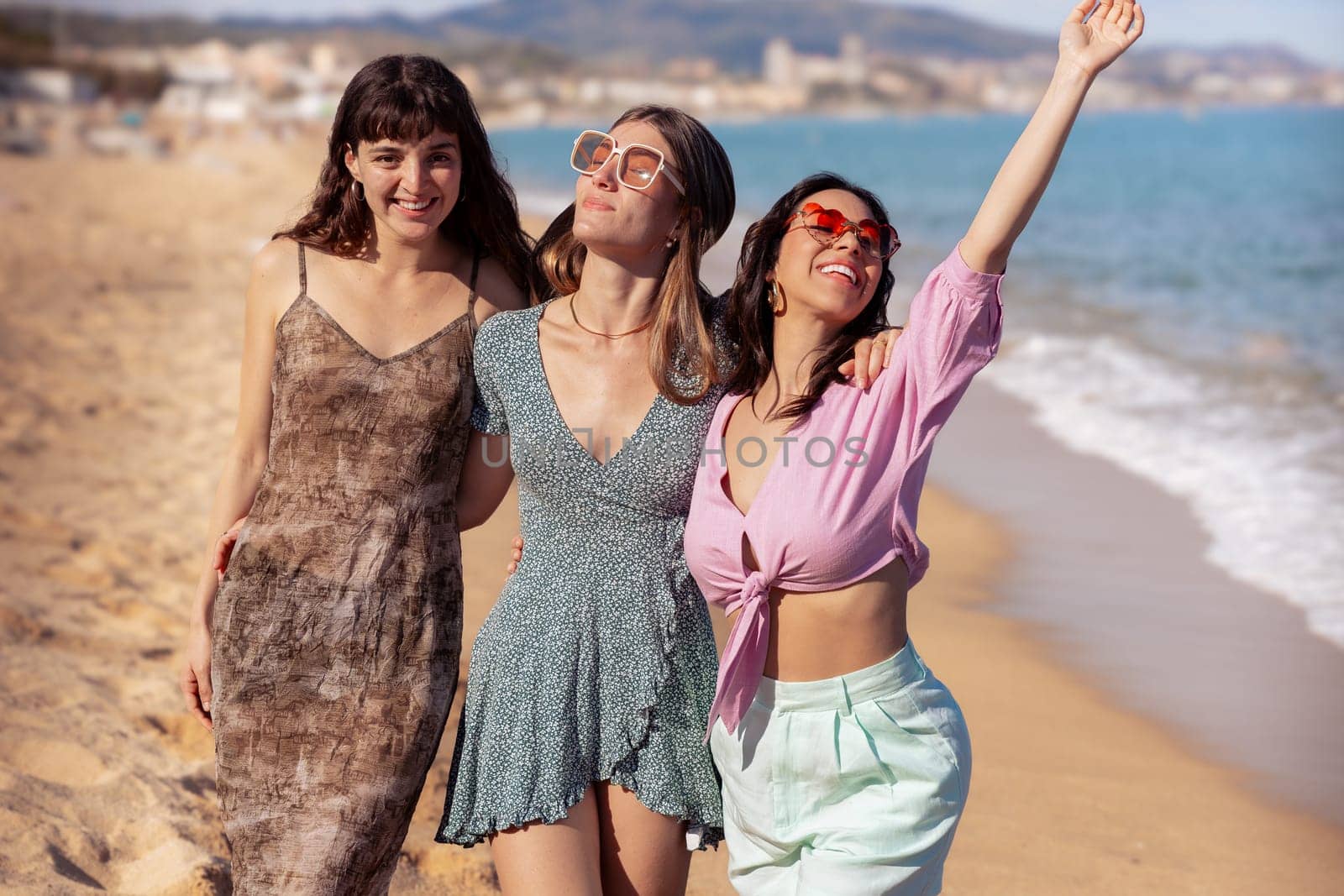 Cheerful multiethnic friends with sunglasses happy on vacation on the beach