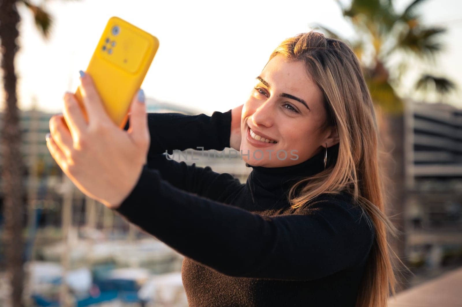 Happy young woman taking a selfie with smartphone.