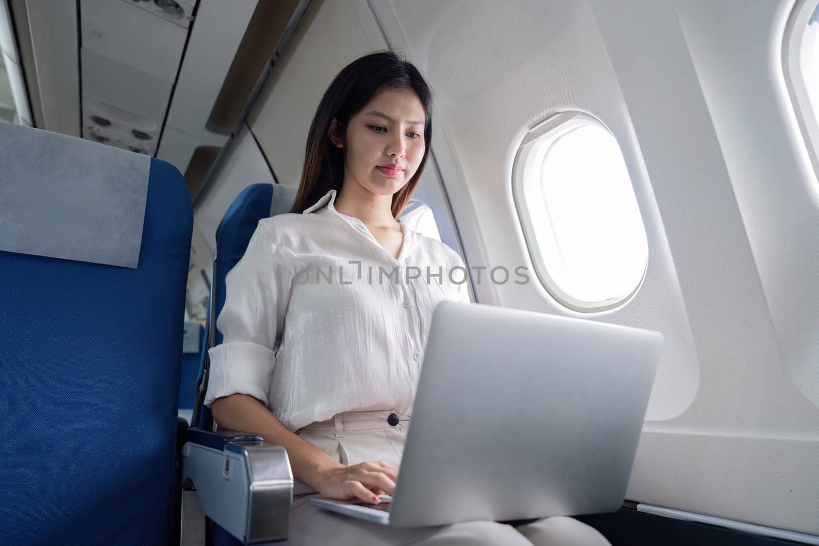 Professional Business Woman Traveling on Airplane, Working on Laptop, Modern Corporate Travel, Business Trip, In flight Productivity, Female Entrepreneur, Air Travel, Business Class, Professional by nateemee