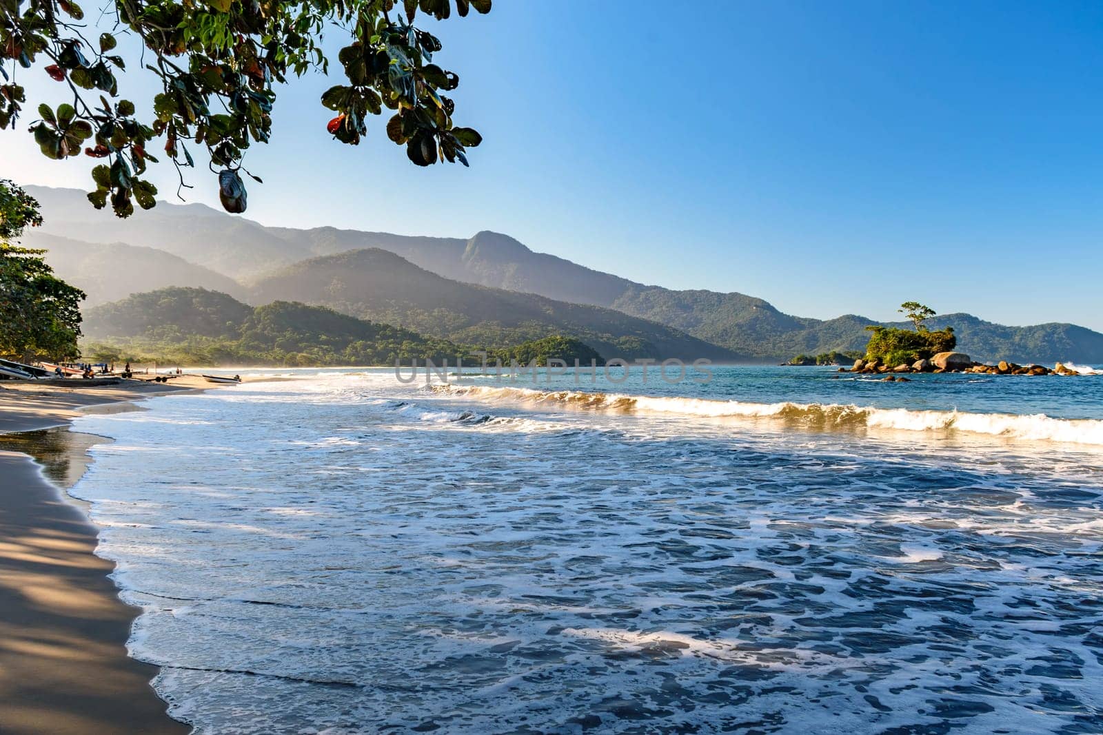 Remote Castelhanos beach on Ilhabela island with mountains and forest around