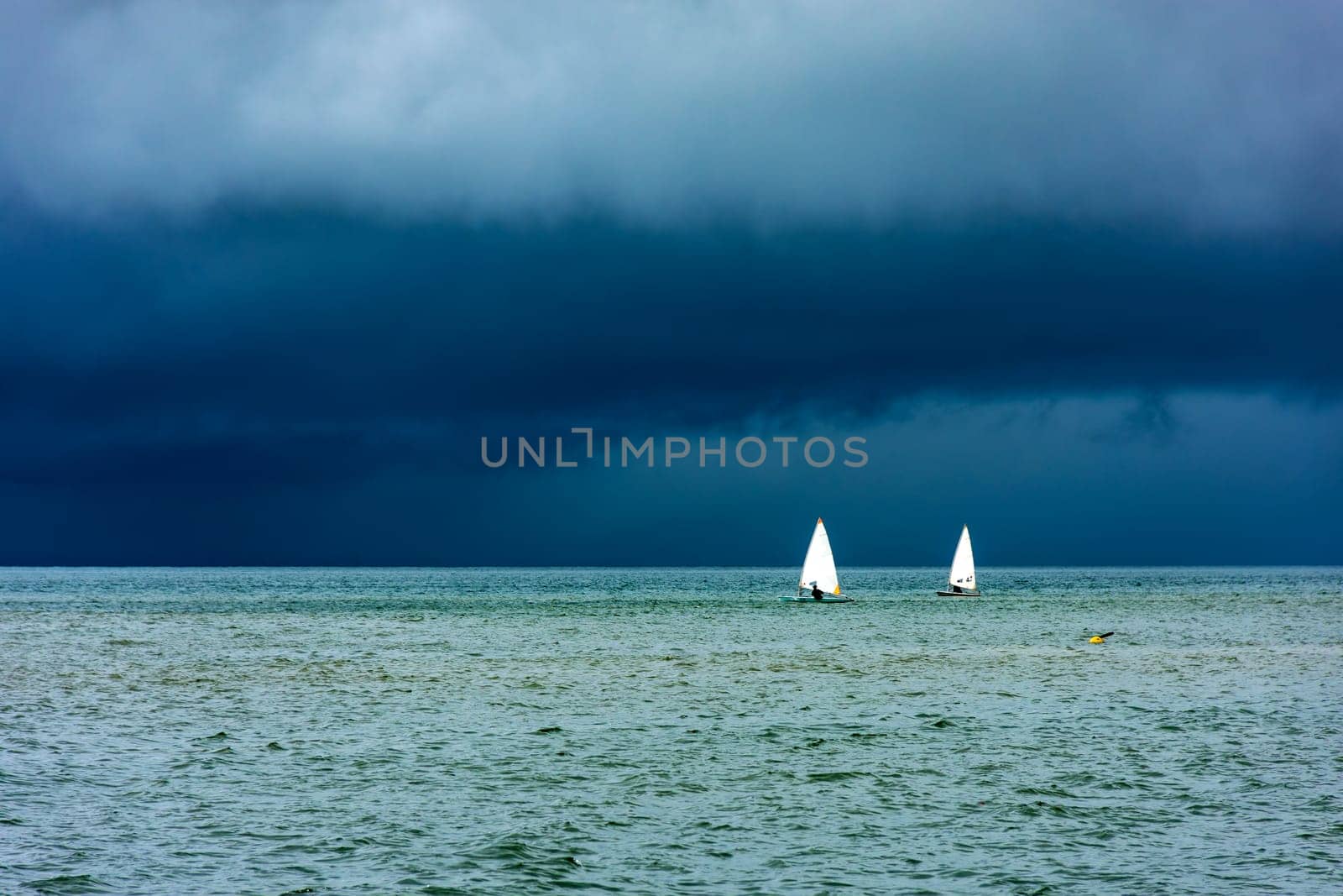 Sailboats sailing the waters of the sea of ​​Ilhabela island before the storm