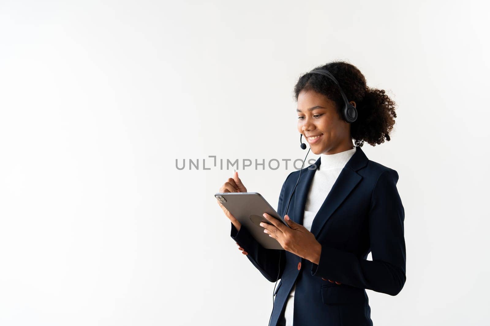 Professional Portrait of a Female Call Center Employee Wearing a Headset and Using a Tablet in a Modern Office Setting by wichayada