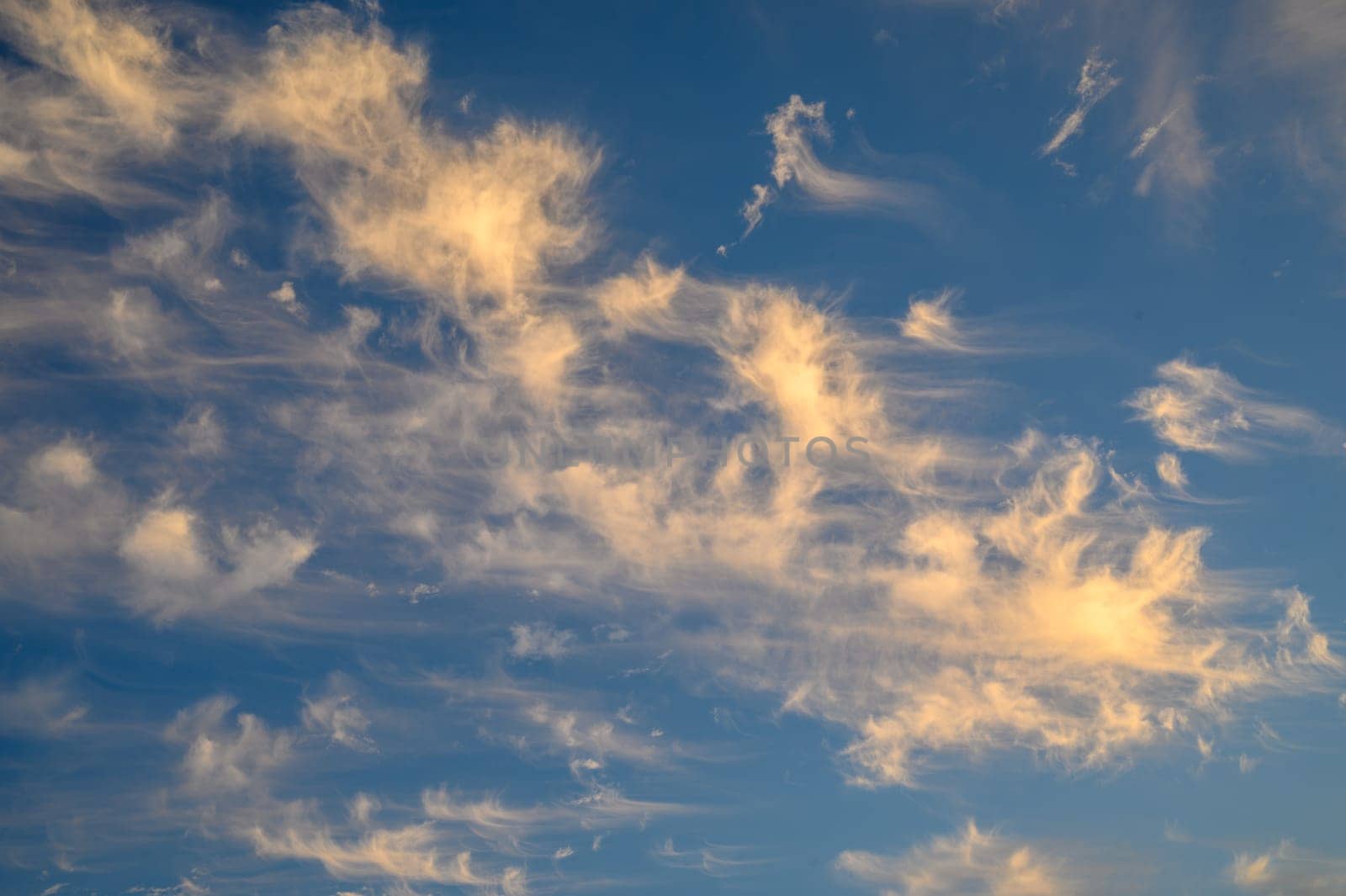 The gathering clouds during sunset create abstract painting patterns in the western sky.