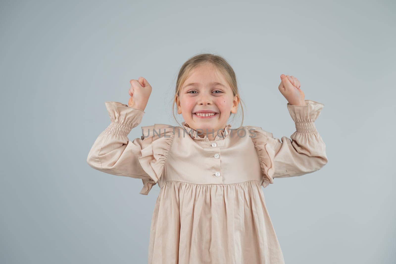 Little Caucasian girl having fun and making faces on a white background