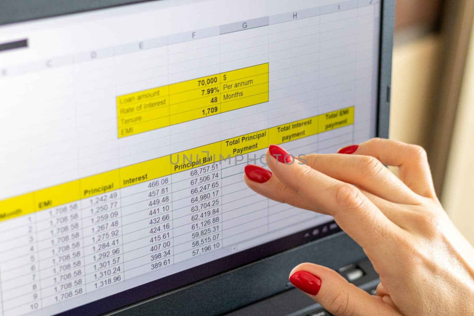 Close up shot of the woman with beautiful hands and manicure, working on the laptop, scrolling touch screen with mortgage loan amortization table open