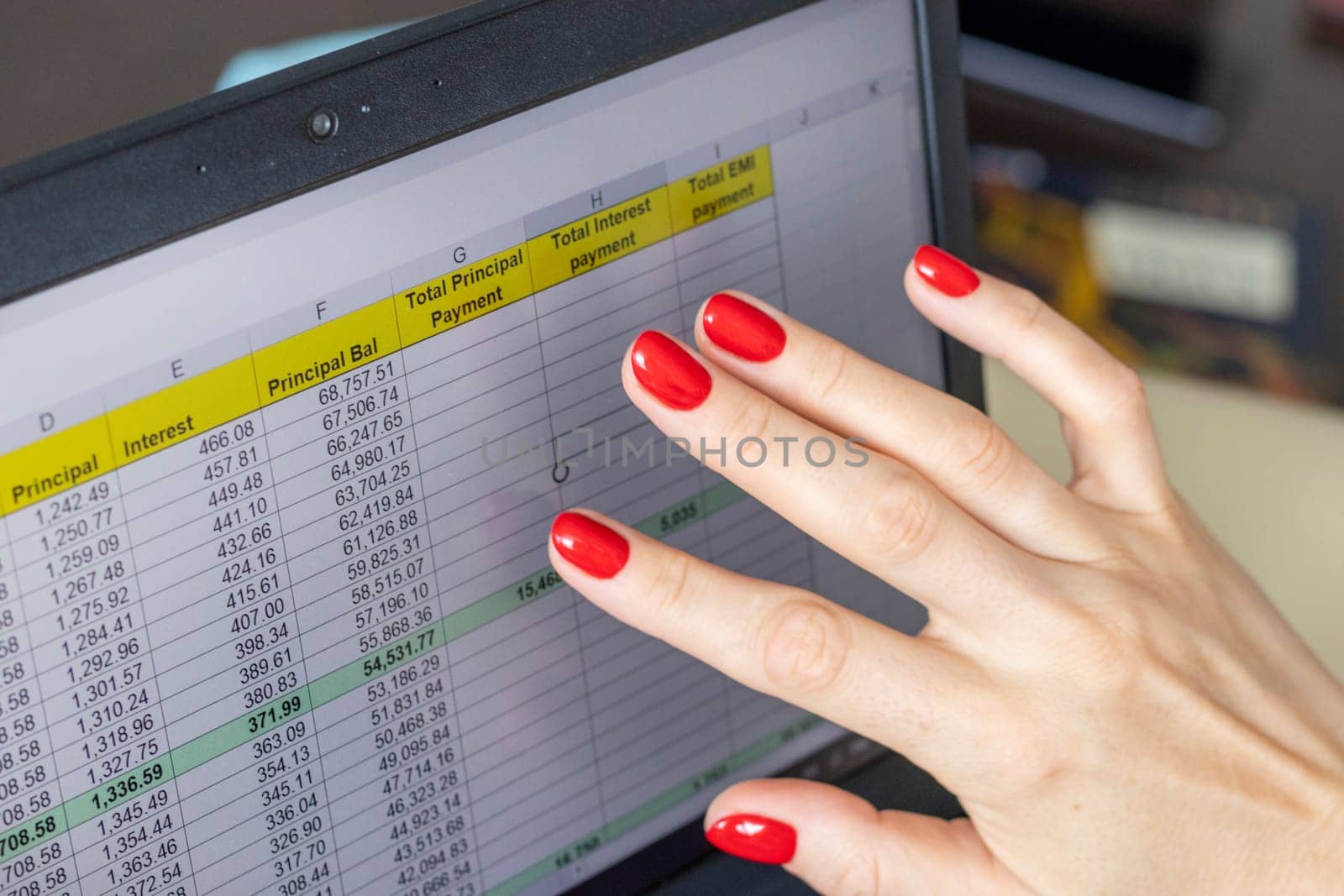 Close up shot of the woman with beautiful hands and manicure, working on the laptop, scrolling touch screen with mortgage loan amortization table open