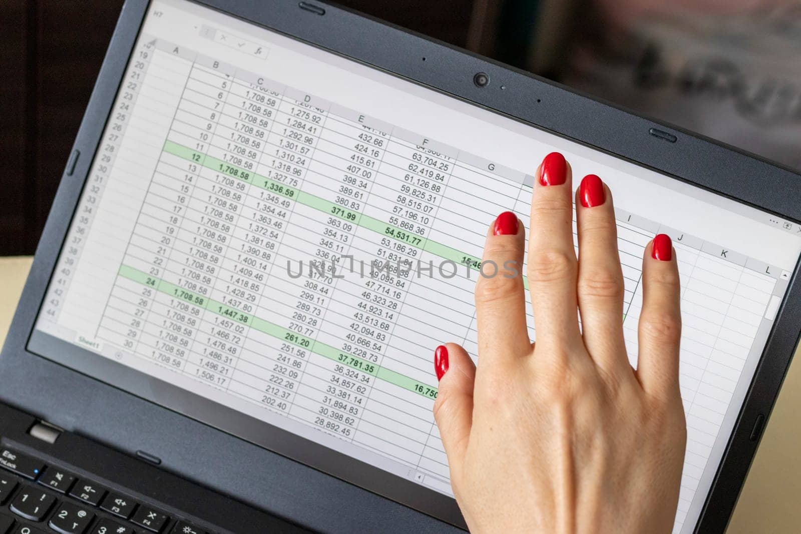 Close up shot of the woman with beautiful hands and manicure, working on the laptop, scrolling touch screen with mortgage loan amortization table open