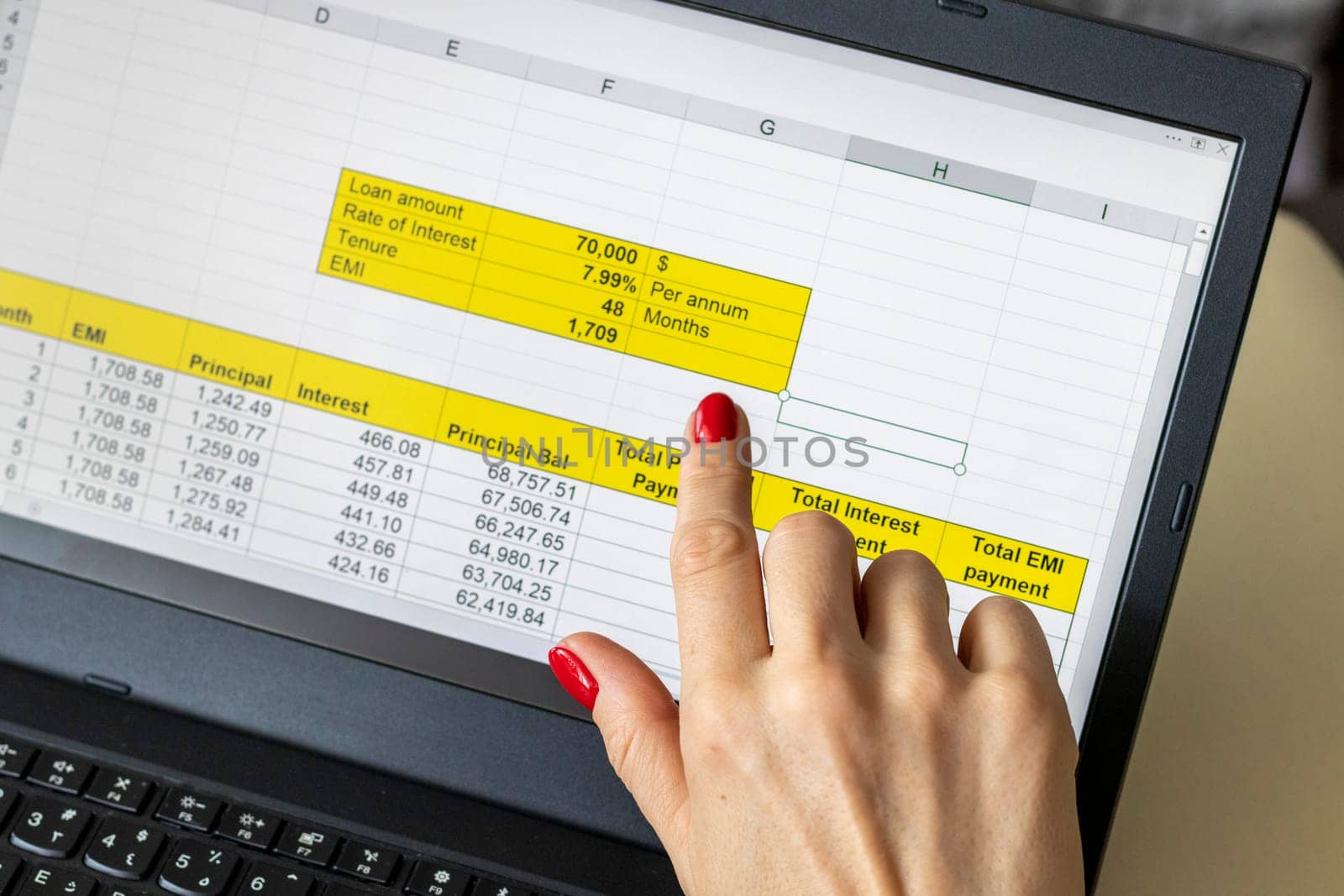 Close up shot of the woman with beautiful hands and manicure, working on the laptop, scrolling touch screen with mortgage loan amortization table open