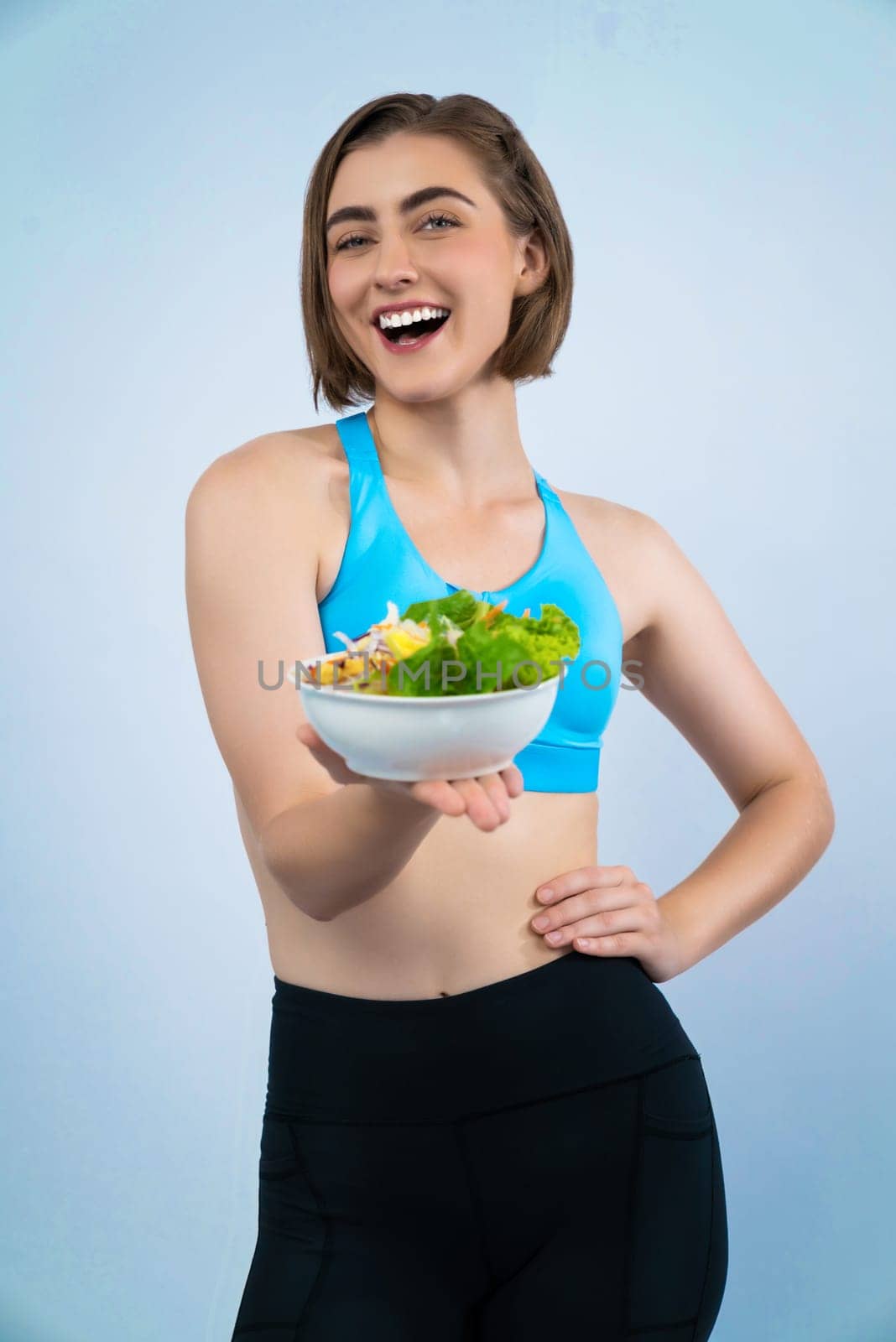 Full body length gaiety shot athletic and sporty young woman with healthy vegan food in standing posture on isolated background. Healthy active and body care by vegetarian lifestyle.