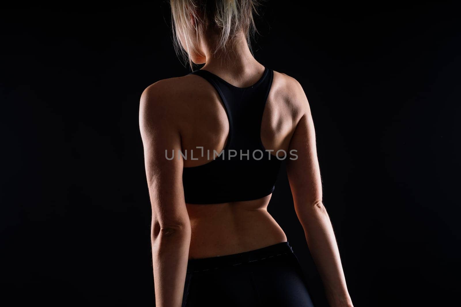 A happy fit woman over studio background. Smiling female fitness workout. Healthy lifestyle concept. by Zelenin