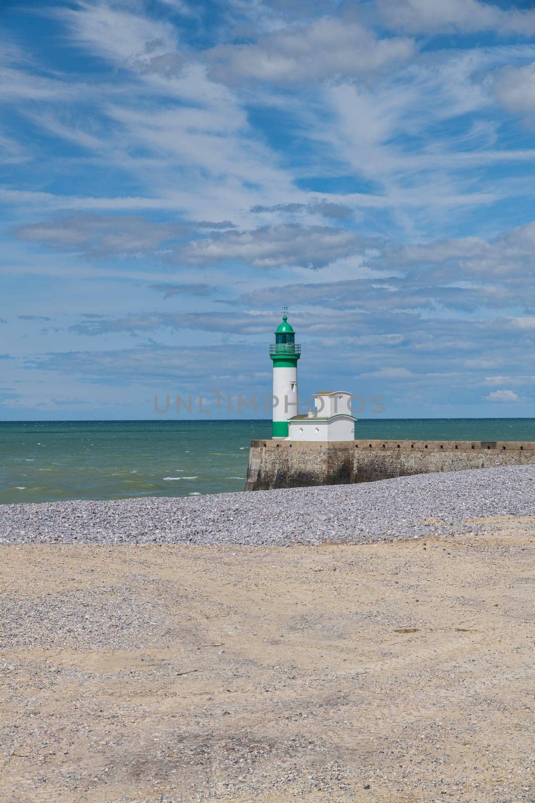 Le Treport lighthouse Seine Maritime, Normandy, France with the beach as foreground and blue sky with clouds as background