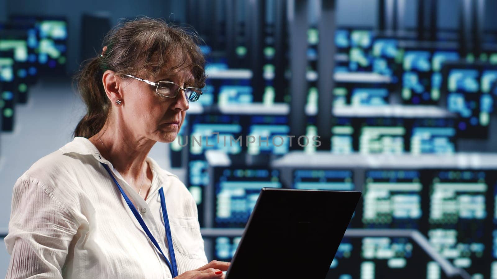 Elderly engineer in data center equipped to handle modern computing requirements, doing regular upgrades to components, increasing processing power, storage capacity and general efficiency