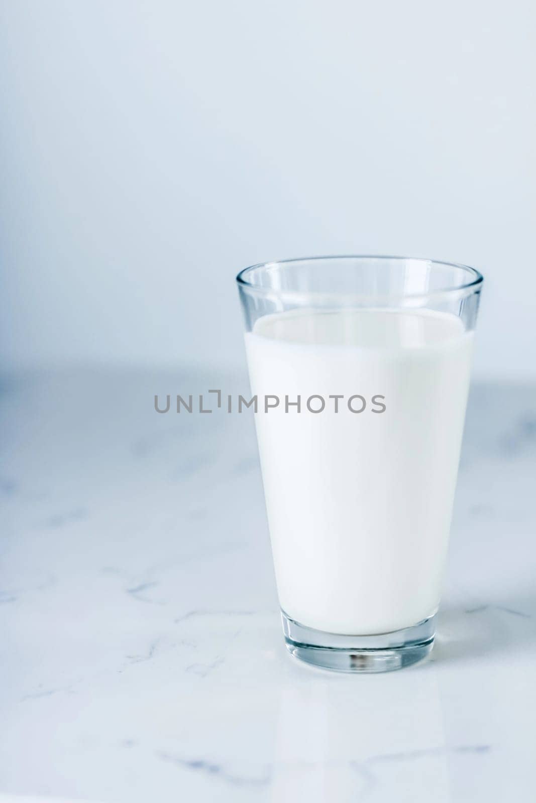 Dairy, healthy nutrition and breakfast concept - World Milk Day, full glass on marble table