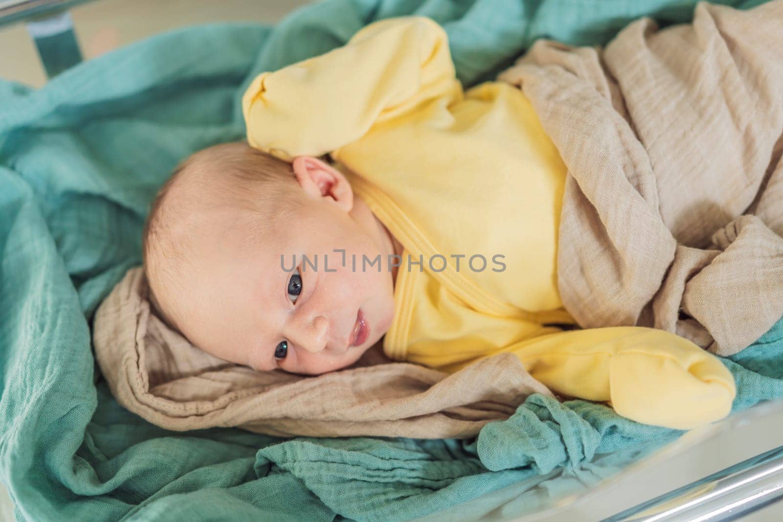 A newborn rests peacefully in his transparent bassinet in the hospital. The clear bassinet provides visibility for medical staff to monitor the baby's well-being while ensuring a safe and comfortable environment for the newborn.