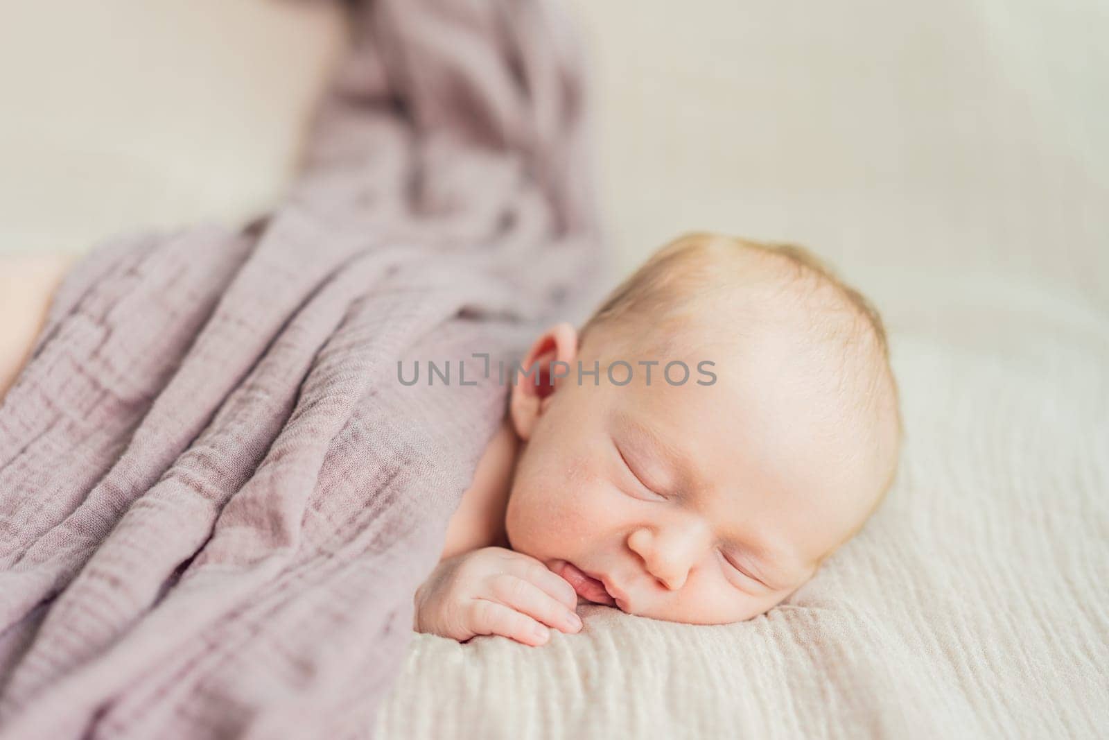 The baby is sleeping peacefully in his cozy nest. Newborn photo session captures the serene innocence and warmth of early moments.