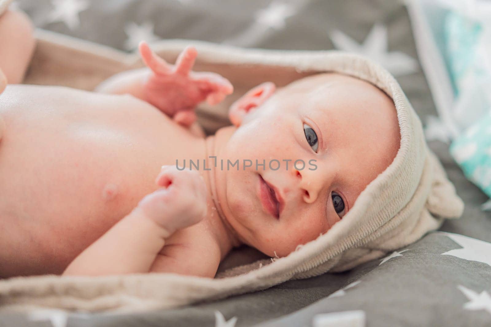 Baby after shower wrapped in a towel. This adorable moment captures the freshness and comfort of a clean baby, highlighting the tender care and love in the daily routine.