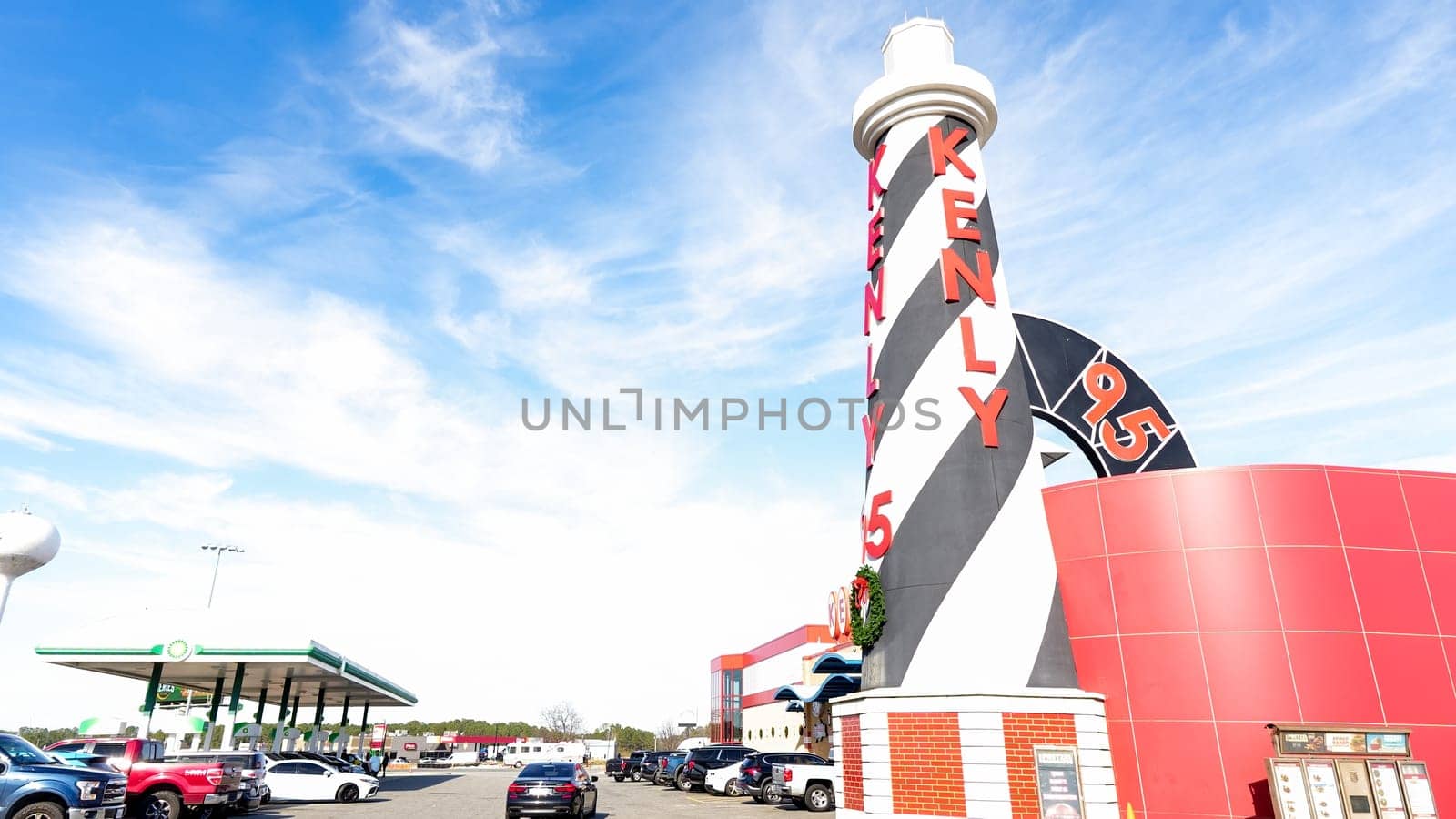 Striped Lighthouse Sign and Building Kenly 95 Truckstop with Blue Sky and White Clouds - Kenly, NC USA 03.15.2024 by JuliaDorian