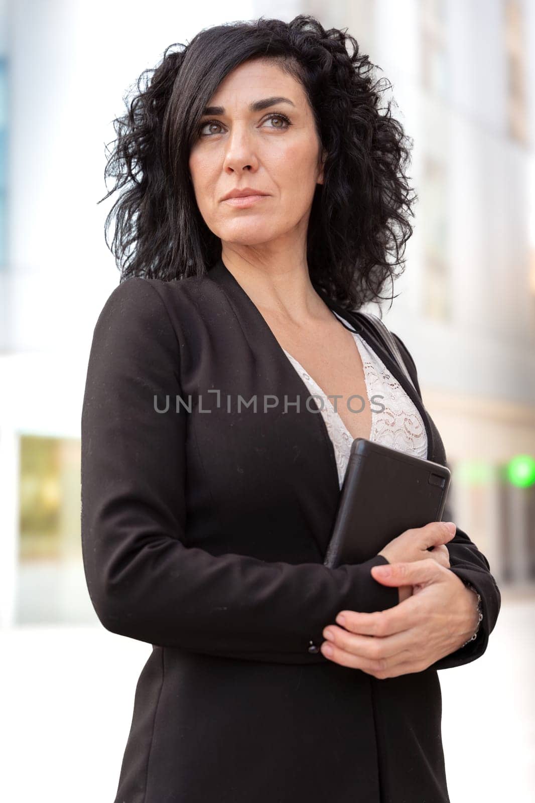 Vertical portrait serious caucasian businesswoman with digital tablet outdoors. by mariaphoto3