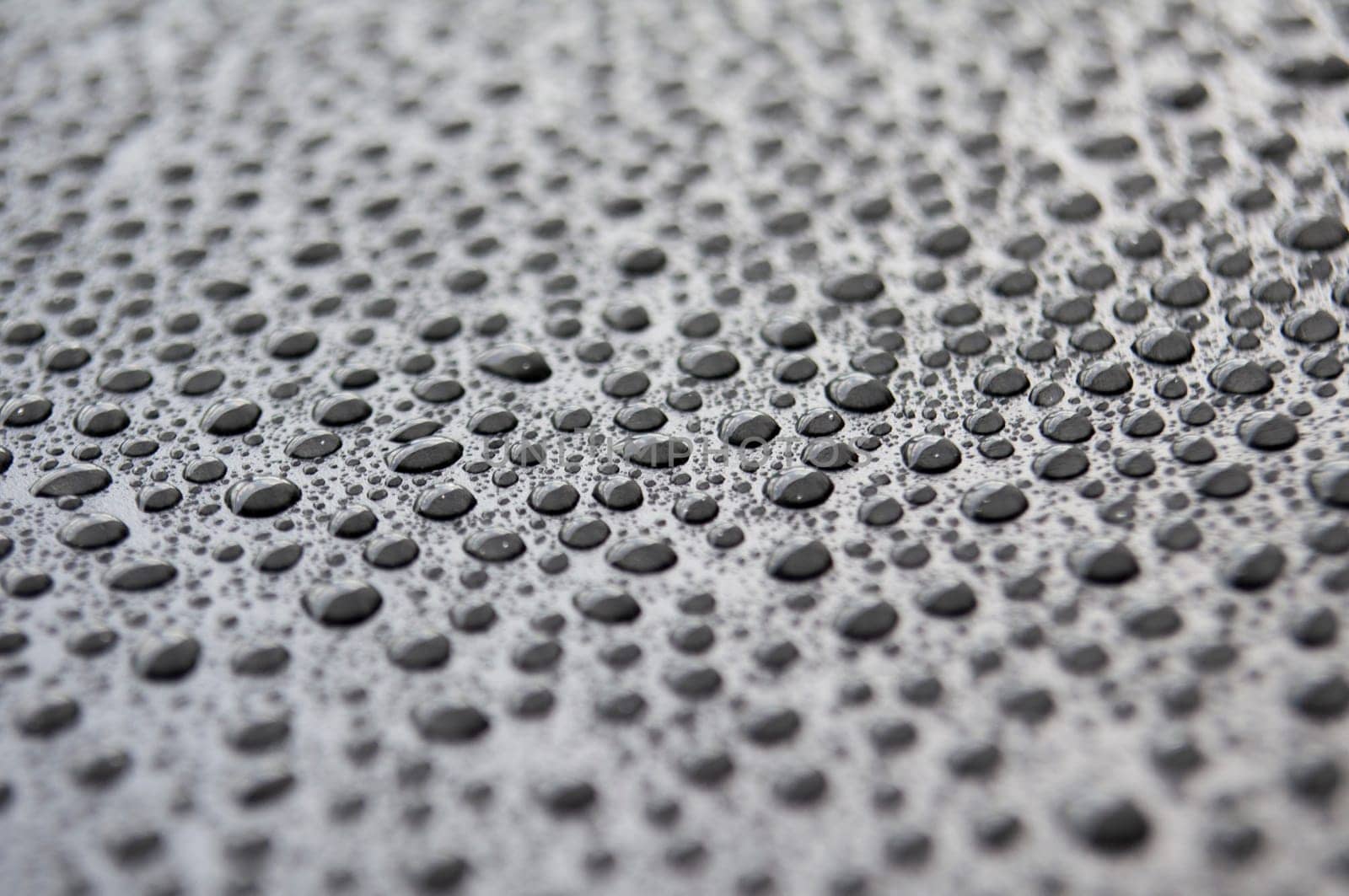 Side view of rain water drop on dark background.