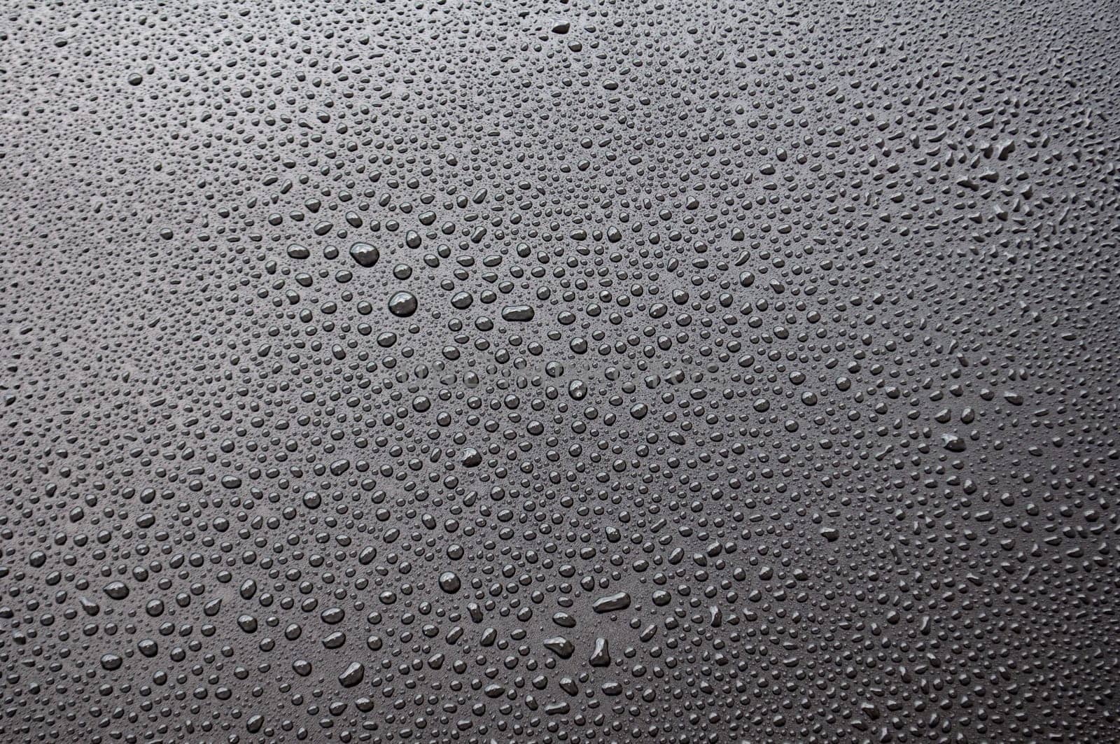 Close up of water droplets on black cover background.