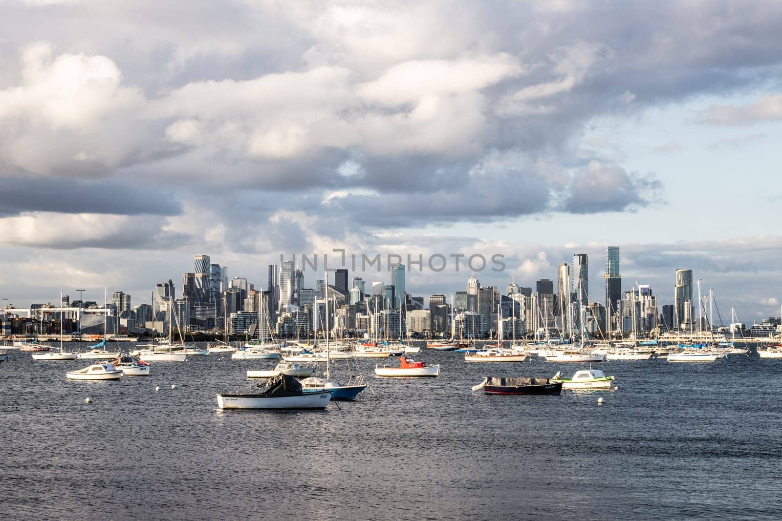Melbourne skyline across Hobsons Bay from Ferguson St Pier in Williamstown waterfront at dusk in winter in Victoria, Australia