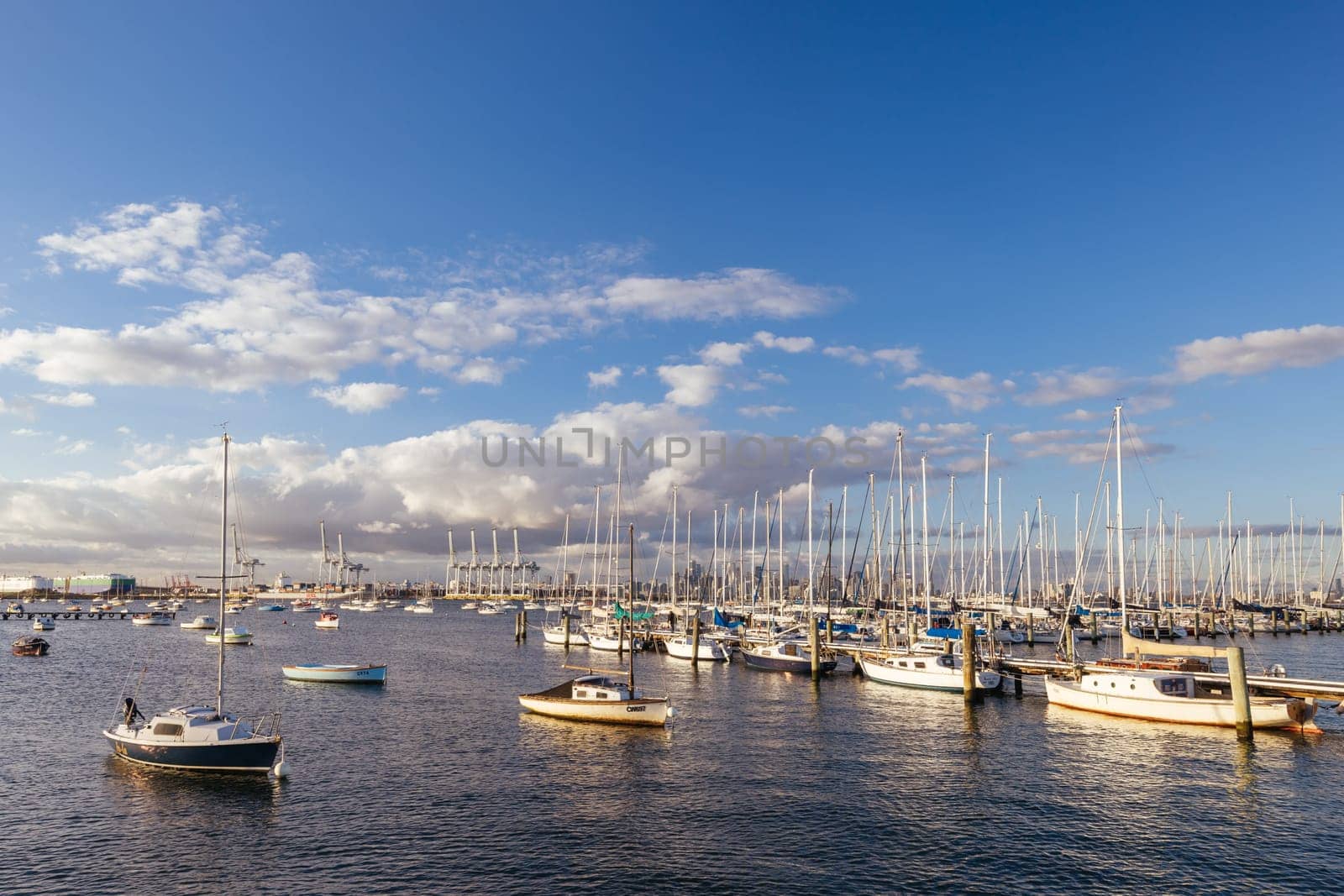 Melbourne skyline across Hobsons Bay from Ferguson St Pier in Williamstown waterfront at dusk in winter in Victoria, Australia