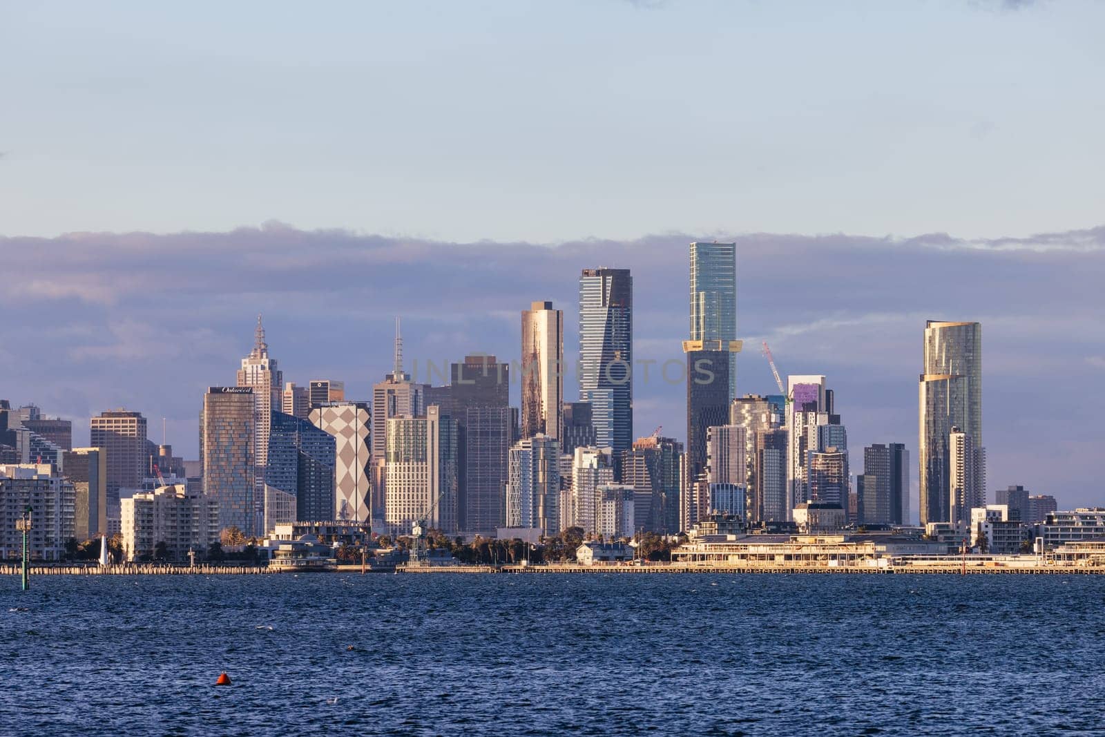 Melbourne skyline across Hobsons Bay from Ferguson St Pier in Williamstown waterfront at dusk in winter in Victoria, Australia