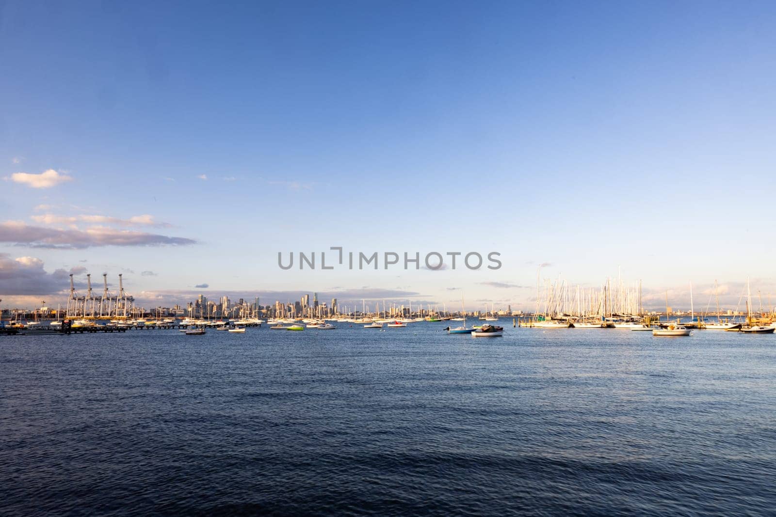 Melbourne skyline across Hobsons Bay from Ferguson St Pier in Williamstown waterfront at dusk in winter in Victoria, Australia