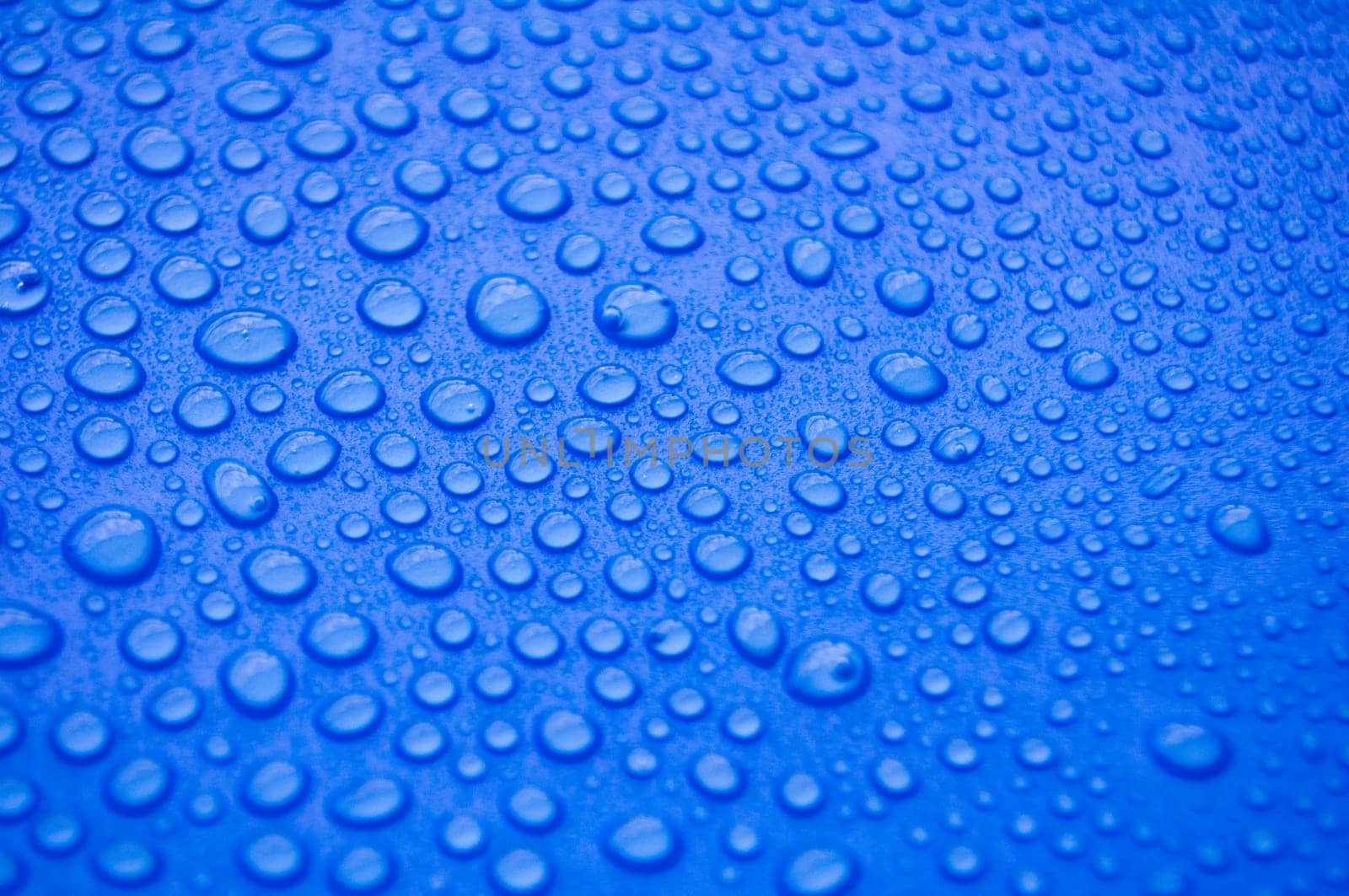 Close up of water droplets on blue cover background