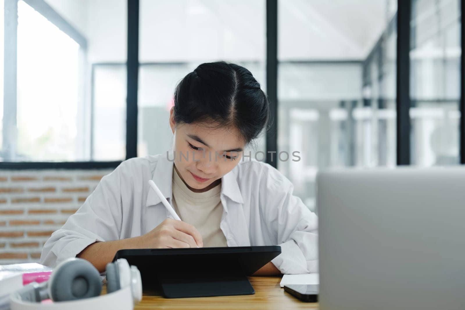 Online education, e-learning. Young collage student using computer and mobile device studying online. Asian young student online learning class study online video call zoom teacher.