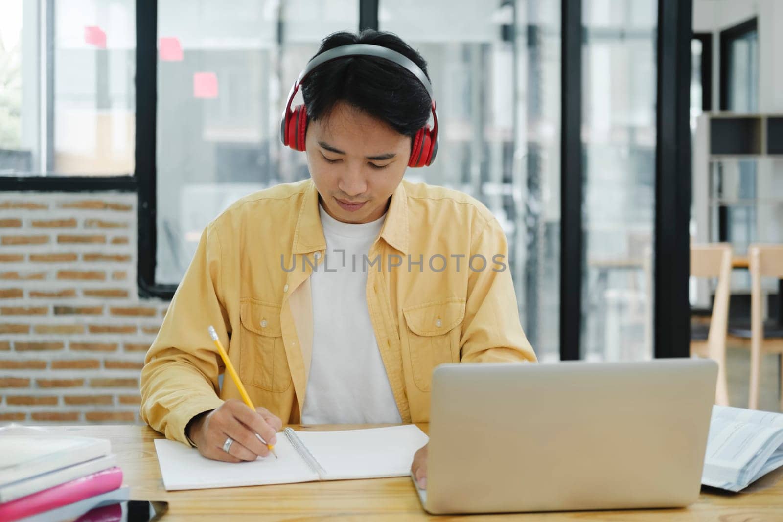 Online education, e-learning. Young collage student using computer and mobile device studying online. Asian young student online learning class study online video call zoom teacher.