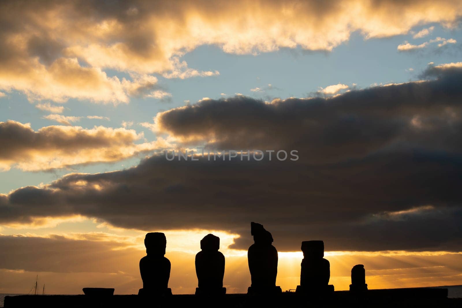 Silhouette shot of the ancient moai on Easter Island in Chile at sunset