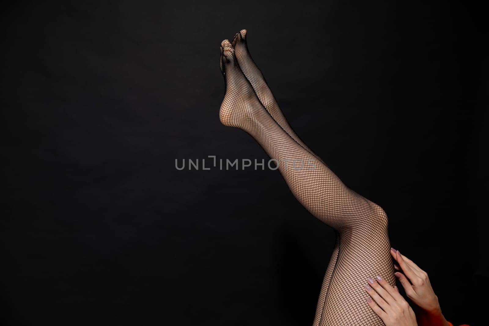 slender beautiful women's legs on a black background by Simakov