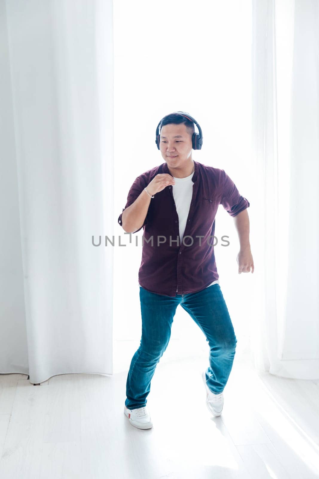 a man in headphones dancing to music in the studio hall by Simakov