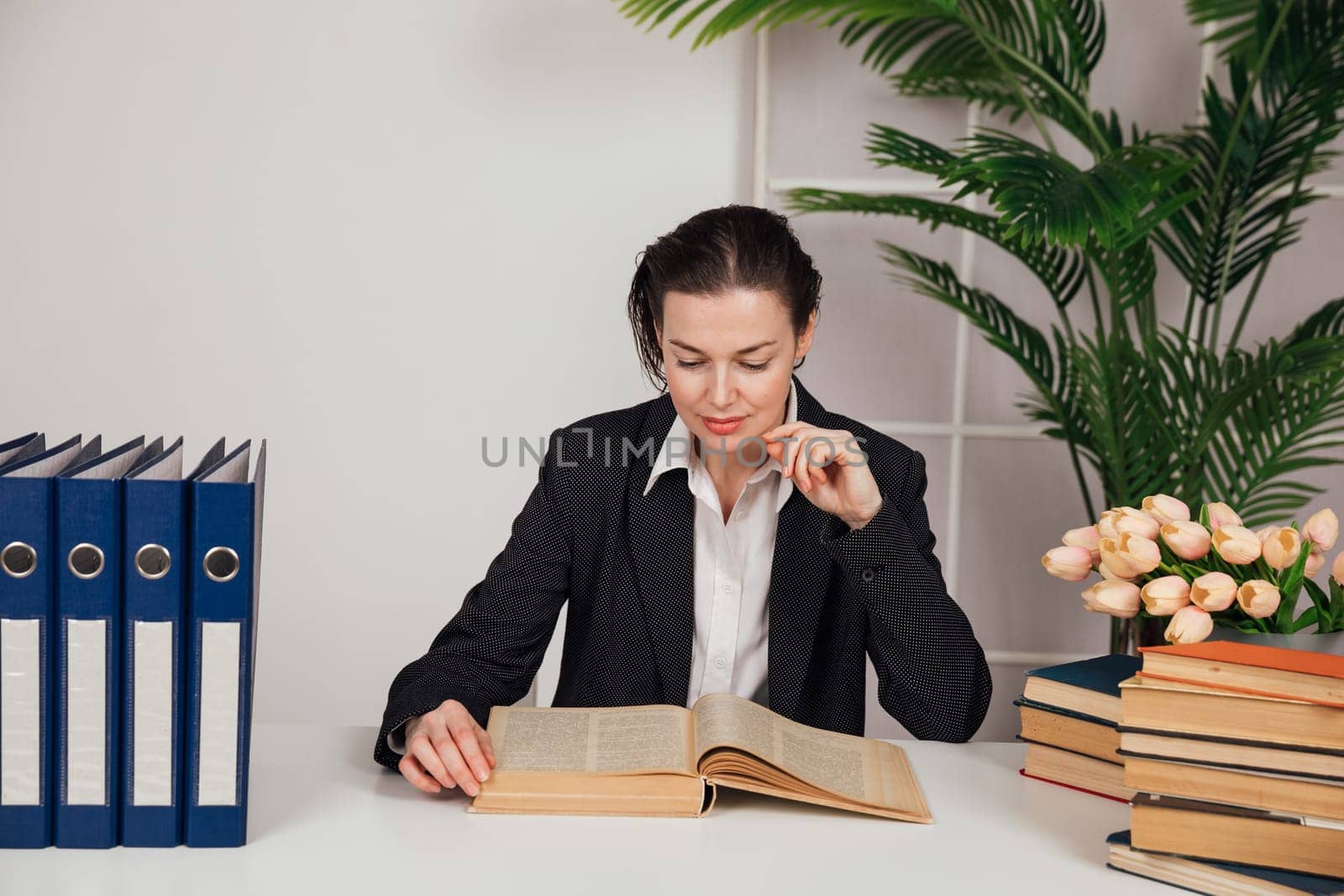 the female director in the office reads a book in the office by Simakov