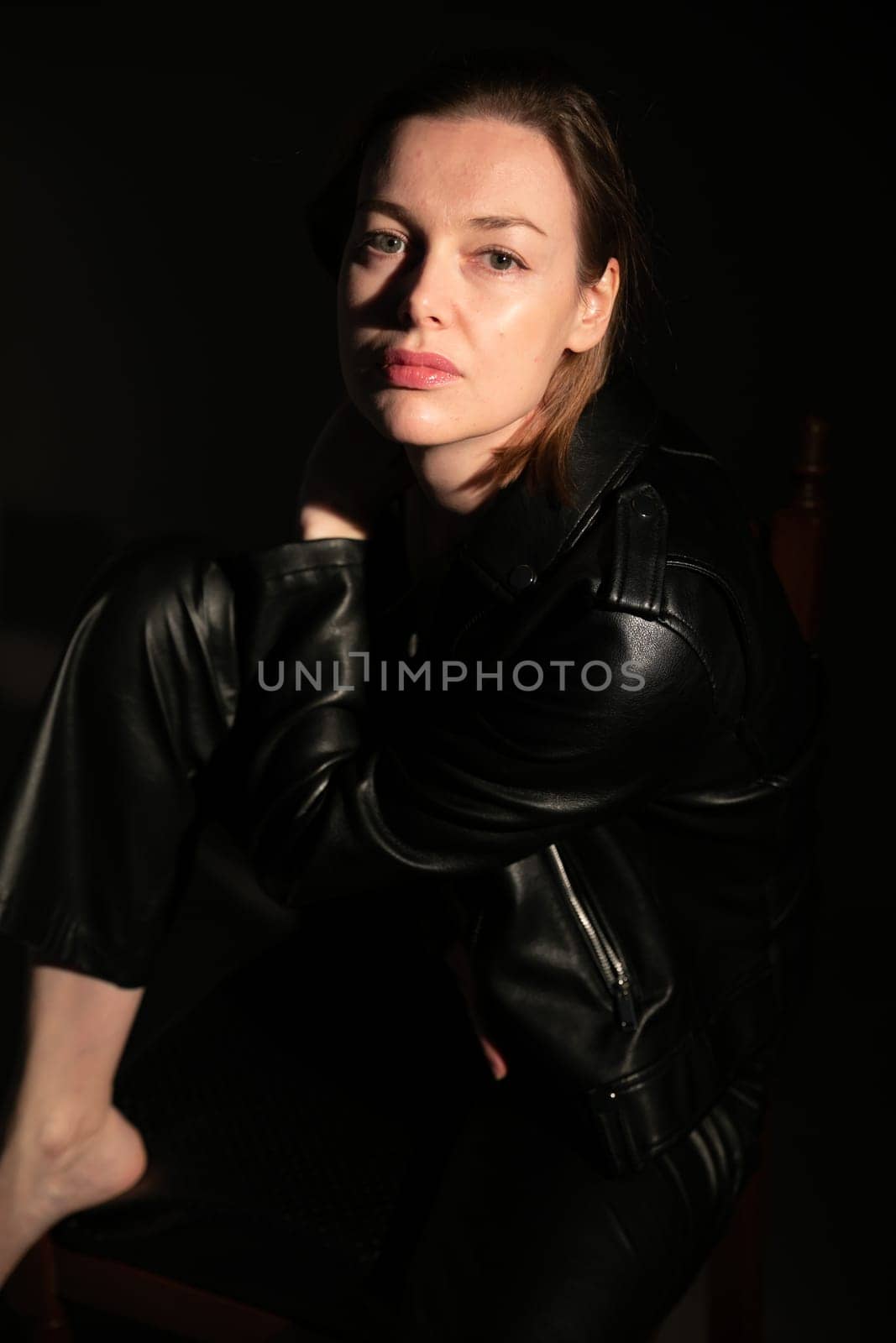 portrait of woman in leather black clothes in the dark