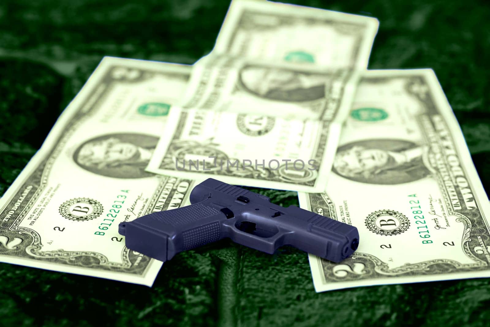 A gun, money dollars on green surface.Criminal,casino,mafia by jovani68