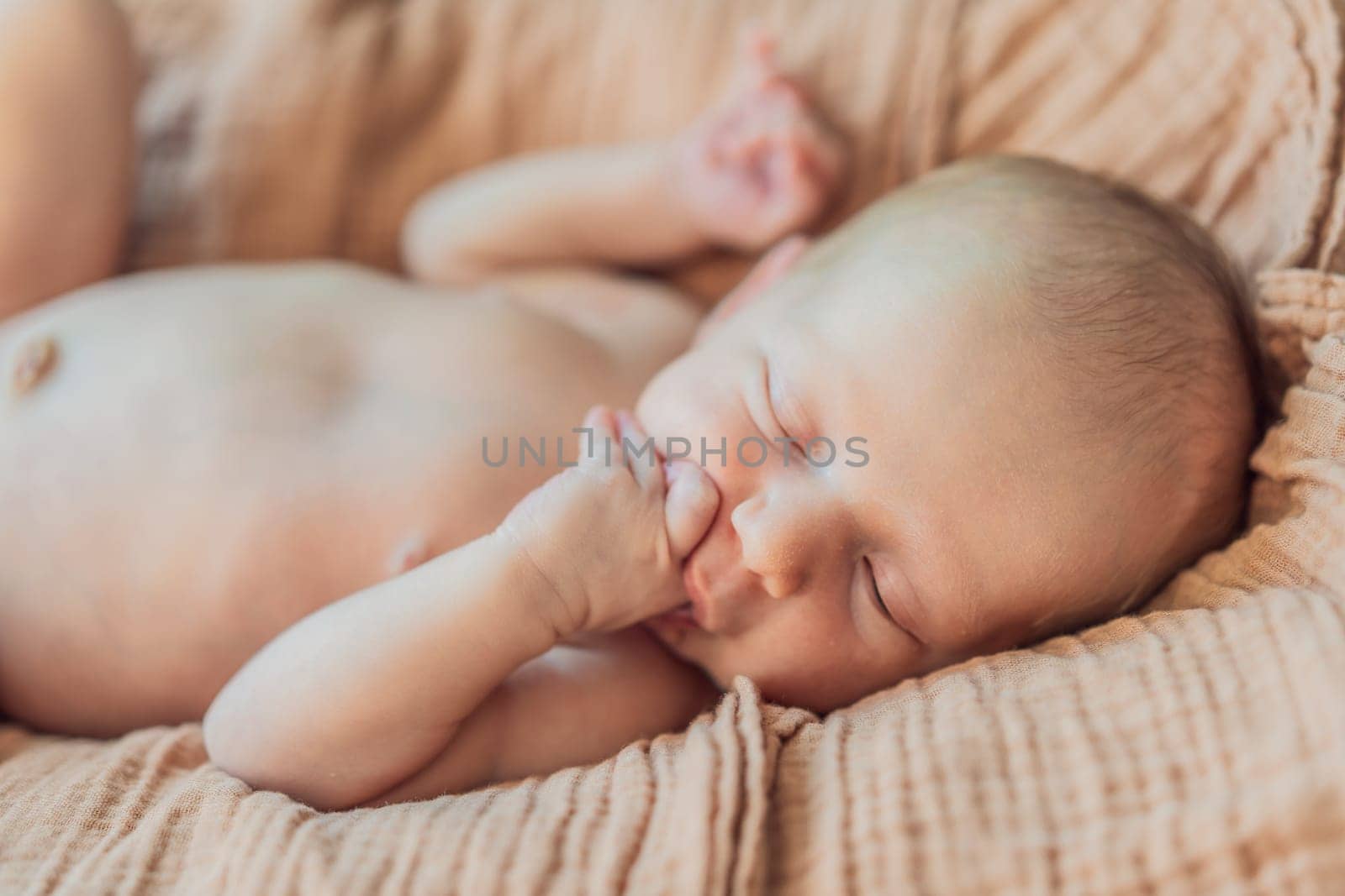 The baby is sleeping peacefully in his cozy nest. Newborn photo session captures the serene innocence and warmth of early moments.