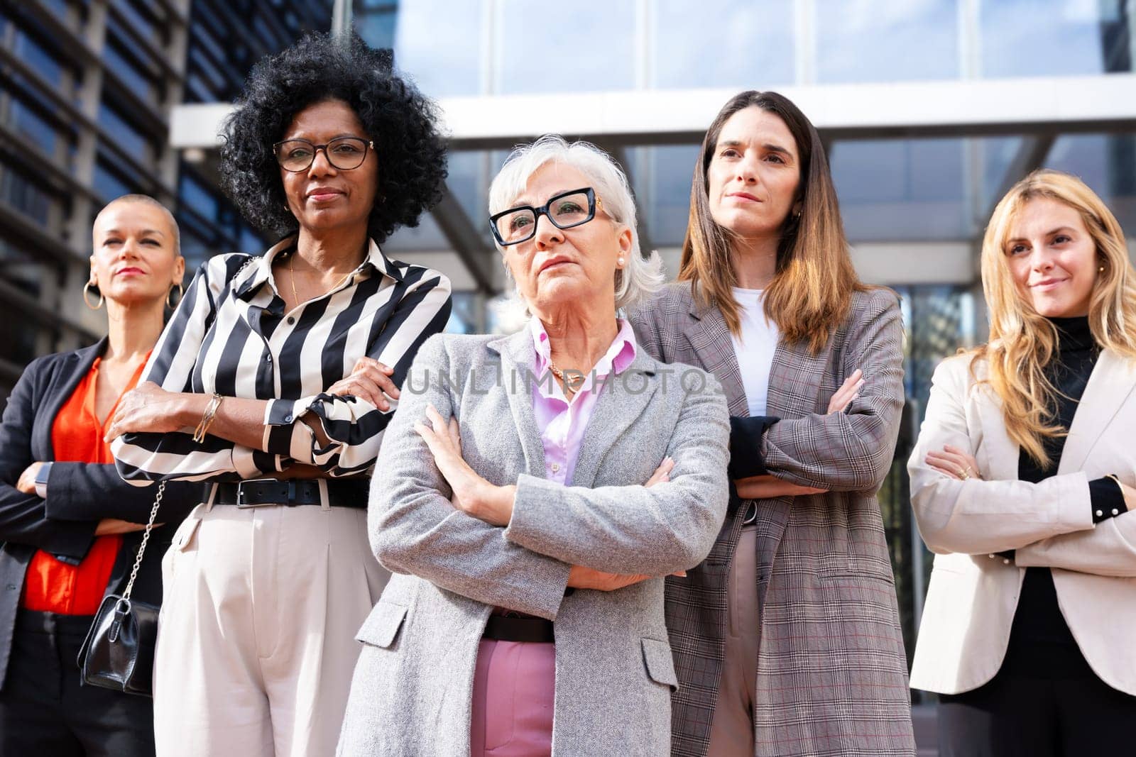 Four multiracial business women posing smiling for the camera. by mariaphoto3