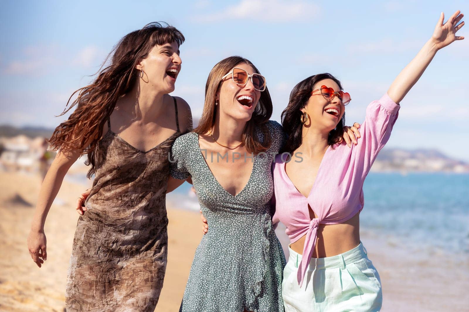 Portrait of three female friends walking on the beach having fun. by molesjuny