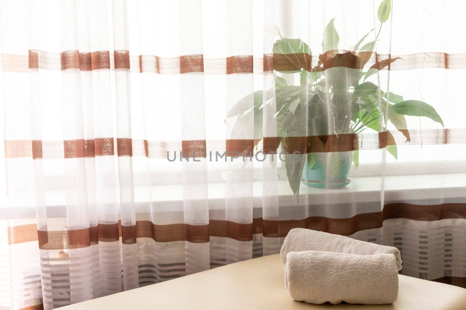 Close up shot of the white towels rolled in the massage couch